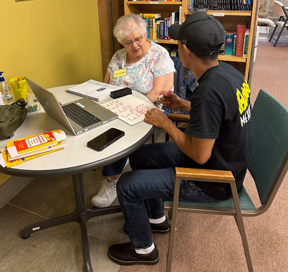 A student and Presentation Lantern Center staff member sit at a table talking.